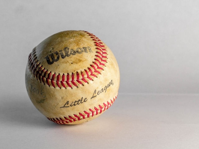 Старый бейсбольный мяч на сером фоне