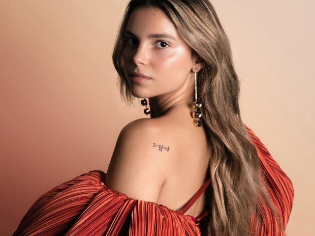 Стильная девушка актриса Инде Наварретт на розовом фоне