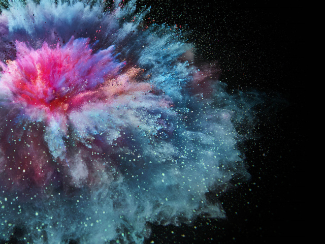 Взрыв разноцветной порошковой краски на черном фоне