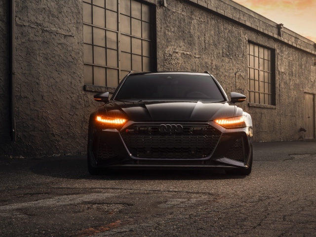 Черный автомобиль Audi RS7 у стены