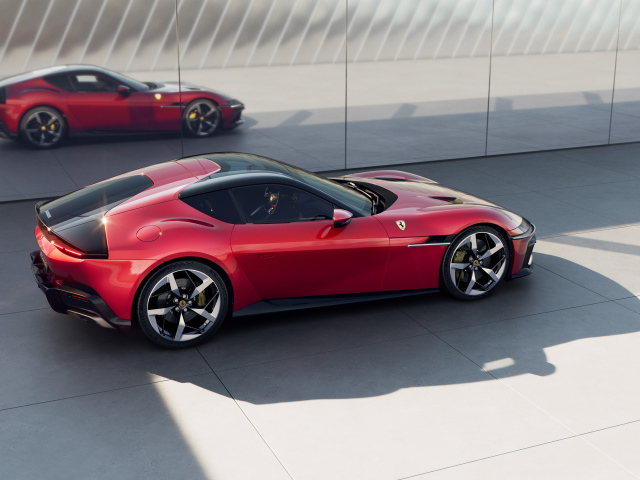 Красный автомобиль Ferrari 12Cilindri 2024 года у стены