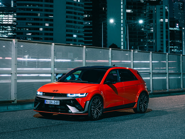 Красный автомобиль Hyundai IONIQ 5 N 2024 года у забора