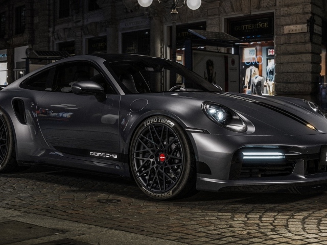 Быстрый автомобиль Porsche 911 Turbo S у здания