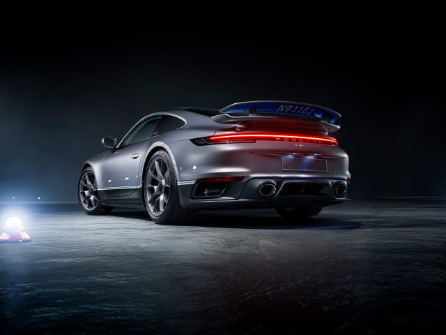 Серебристый автомобиль Porsche 911 Turbo S вид сзади