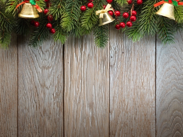 Деревянный новогодний фон с еловой веткой и колокольчиками