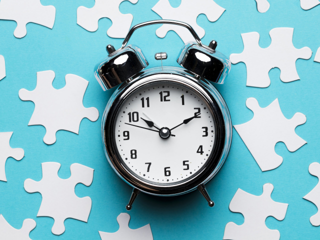 Будильник на голубом фоне с пазлами