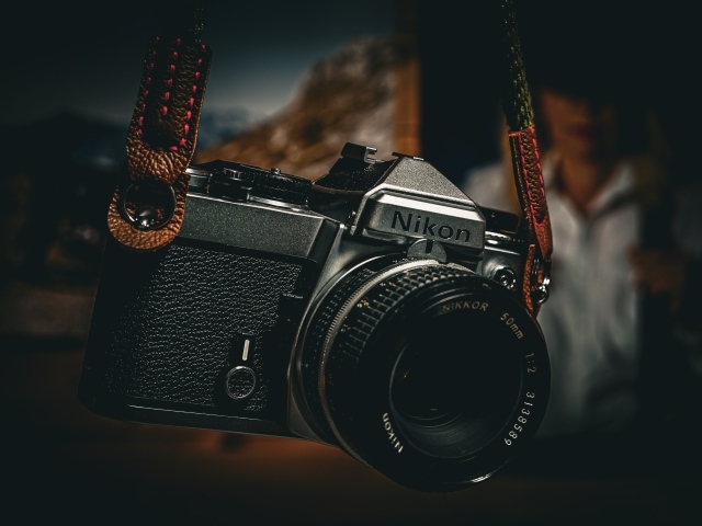 Черный фотоаппарат nikon на ремне