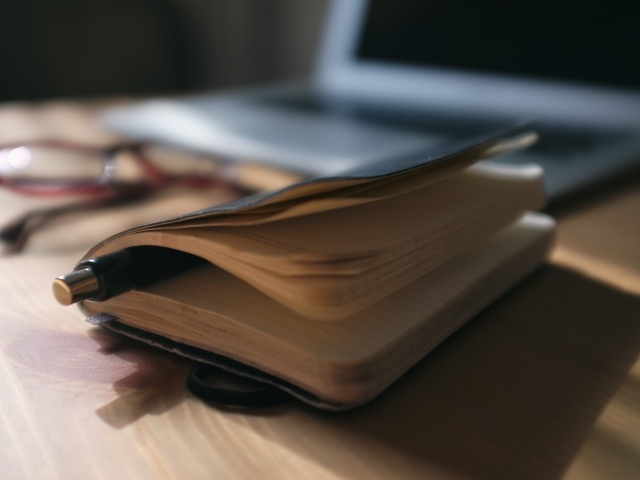 Блокнот с ручкой на столе