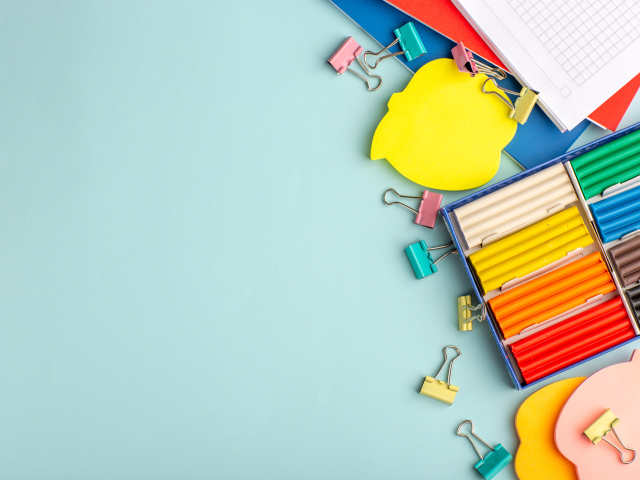 Пластилин на голубом фоне со скрепками и блокнотами