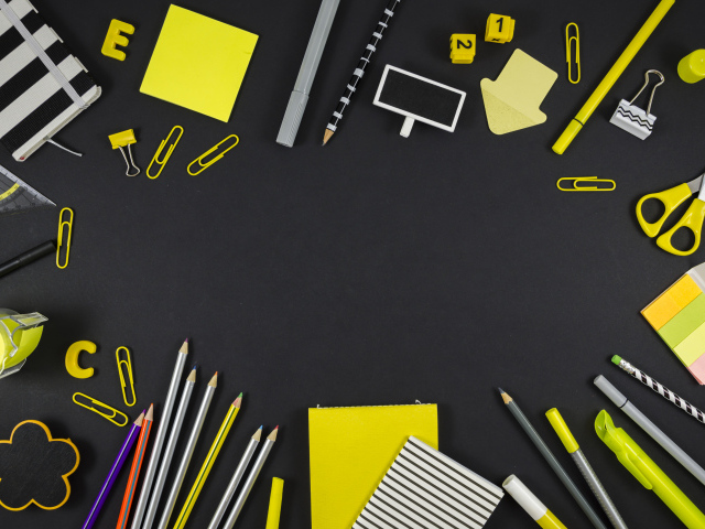 Желтые разные канцелярские предметы на черной поверхности 