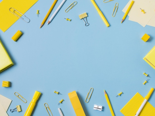 Желтые канцелярские предметы на голубом столе