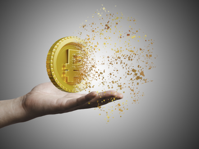 Монета разрушается на ладони на сером фоне