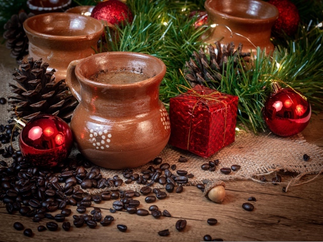 Кофейные зерна на столе с посудой и еловой веткой