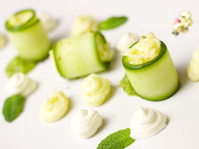 Рулетики из огурца с кремом на белом фоне
