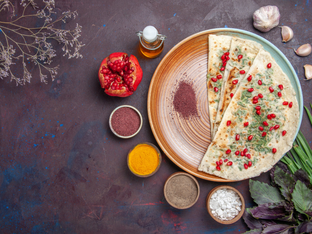 Лепешки на столе со специями и зеленью