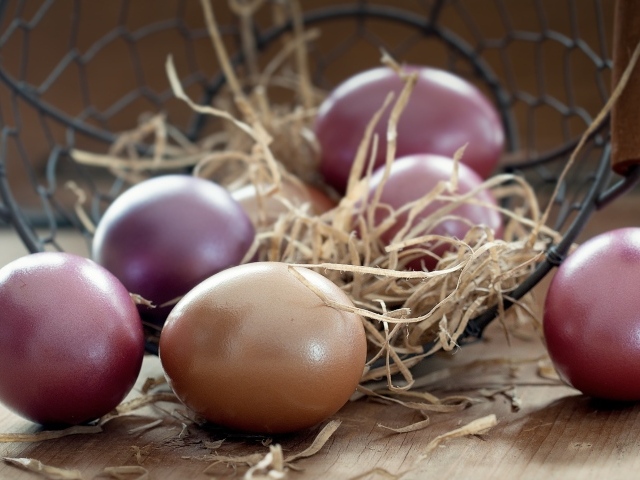 Разноцветные яйца на столе с сеном