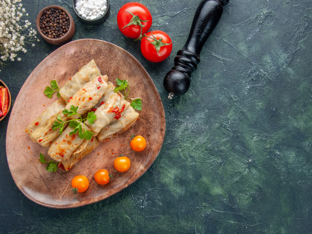 Голубцы на столе с помидорами и специями