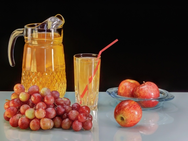 Сок на столе с виноградом и яблоками