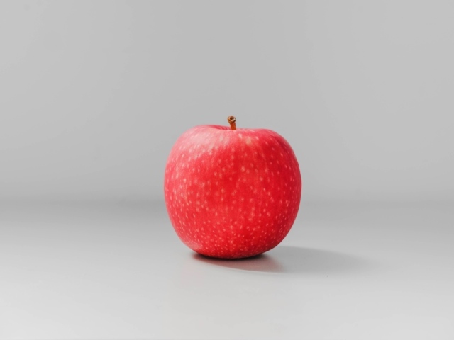 Одно красное яблоко на сером фоне