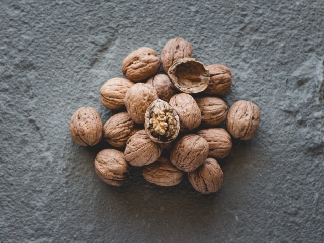 Куча грецких орехов на сером столе