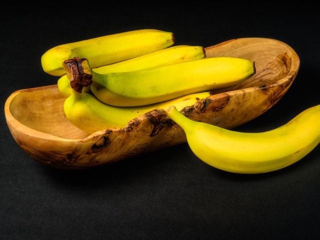 Деревянная чаша с бананами на столе