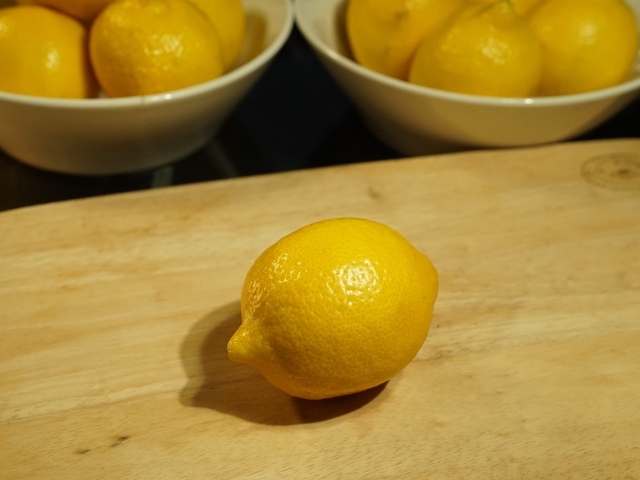 Желтый лимон на деревянной доске на столе