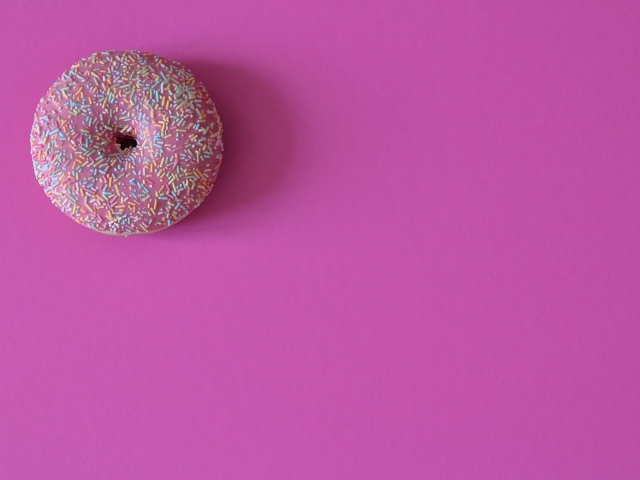 Аппетитный донат с глазурью на розовом фоне