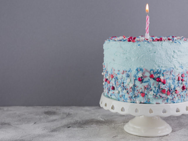 Праздничный торт в голубой глазури с одной свечкой
