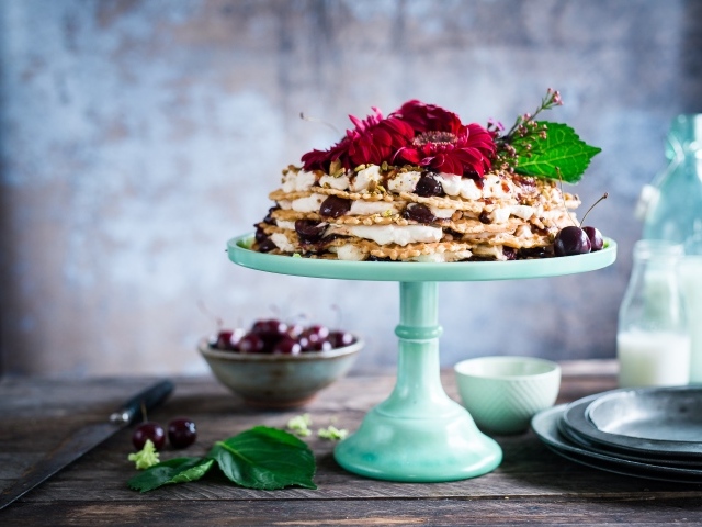Торт с черешней и цветами герберы на столе