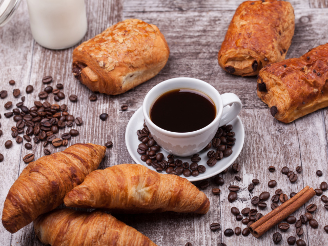 Кофе на столе с круассанами и зернами