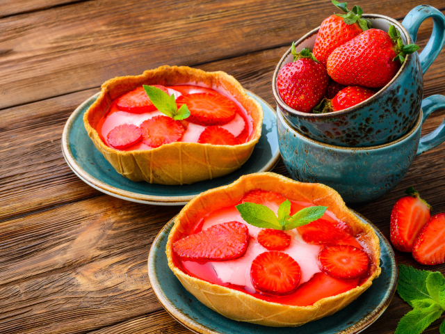 Вкусные пирожные с ягодами клубники на тарелке