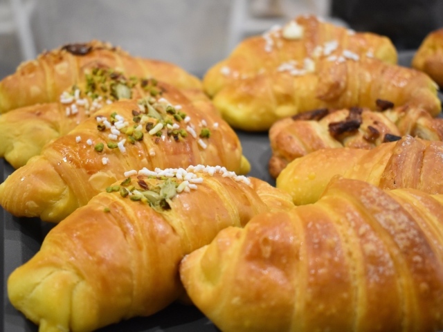 Вкусные сладкие круассаны на противне