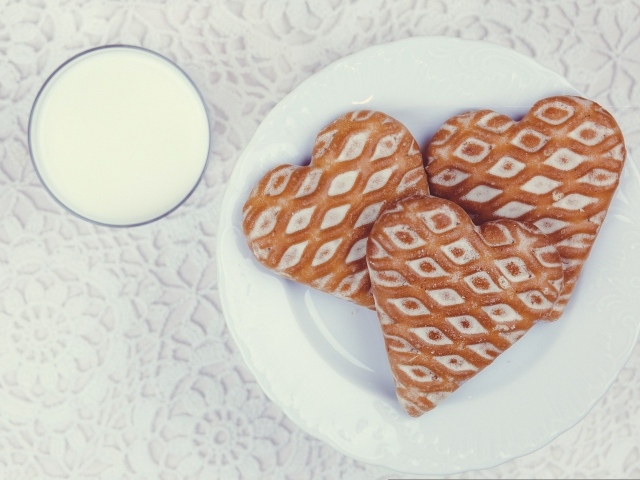 Печенье в форме сердца на столе с молоком