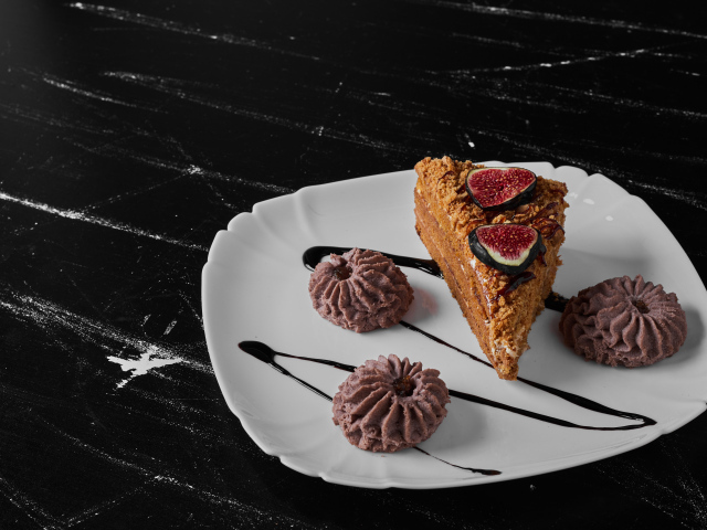 Кусок торта с печеньем на белой тарелке