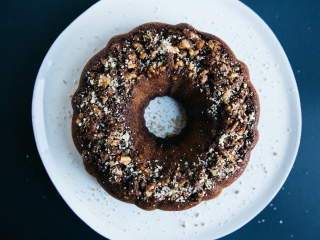 Круглый шоколадный кекс на большой белой тарелке