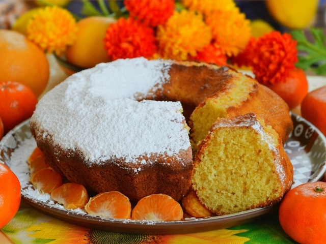 Сладкий пирог на столе с мандаринами и апельсинами