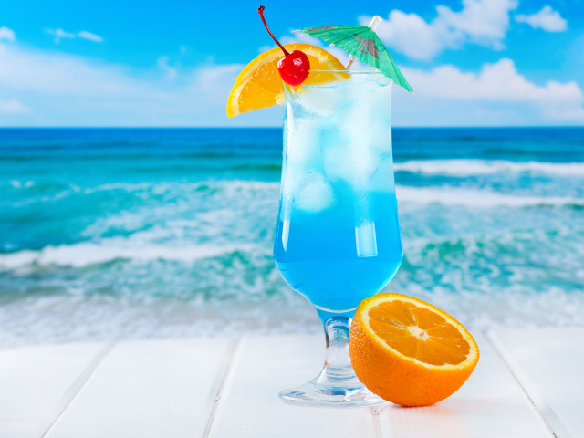 Голубой коктейль со льдом и половинкой апельсина