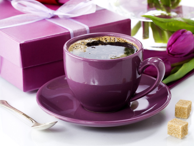 Чашка кофе с подарками и цветами на столе