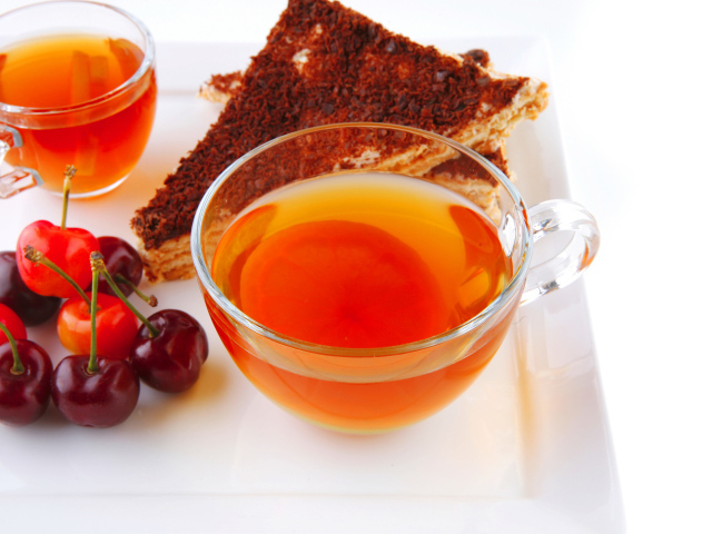 Чашка чая с тортом и ягодами черешни
