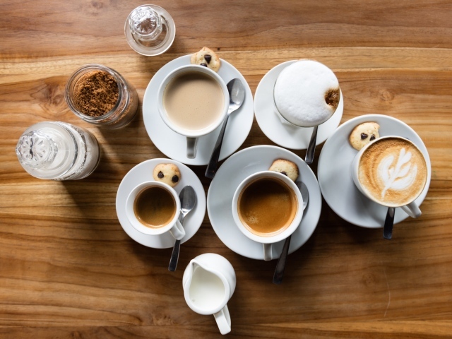Чашки с кофе на столе с сахаром и молоком