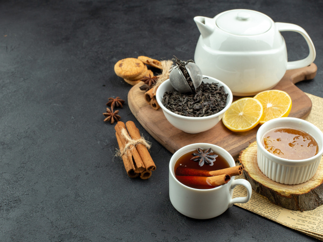 Вкусный чай на столе с лимоном и пряностями