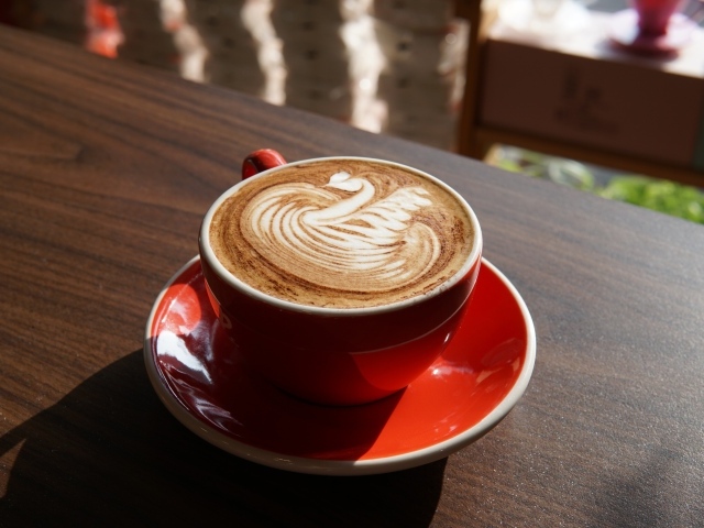 Латте с красивой пенкой в красной чашке