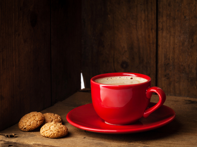 Красная чашка кофе на столе с печеньем