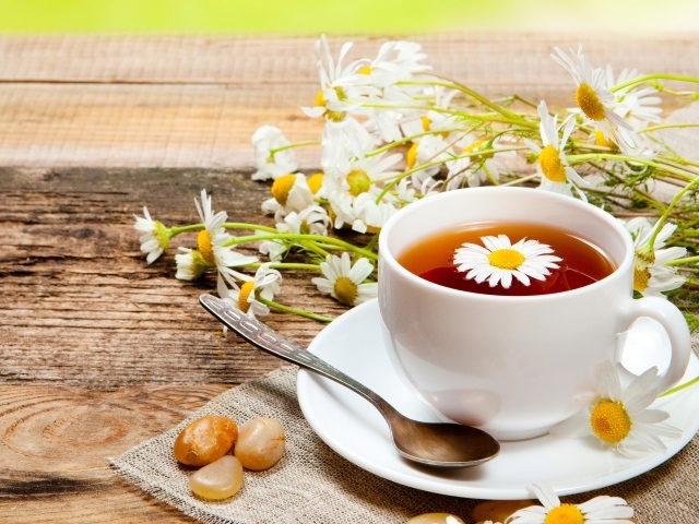 Чай на столе с цветами ромашки и конфетами