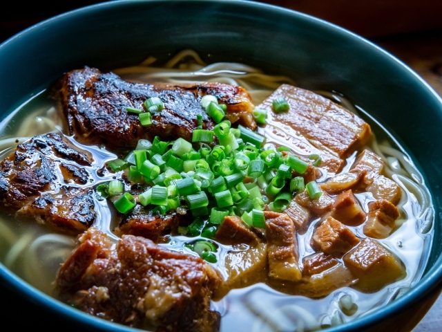 Лапша с мясом и зеленым луком в тарелке