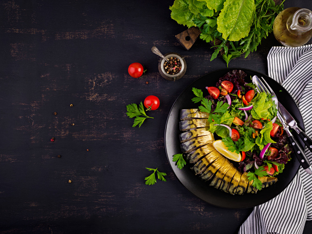 Скумбрия с салатом на тарелке на столе