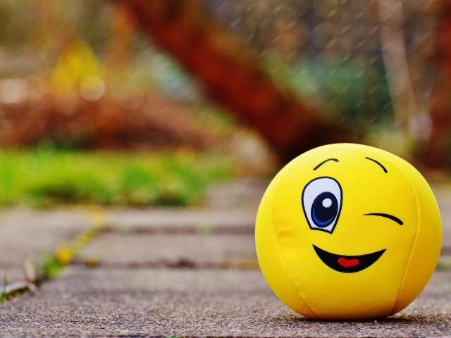 Желтый мягкий мяч смайл на дороге