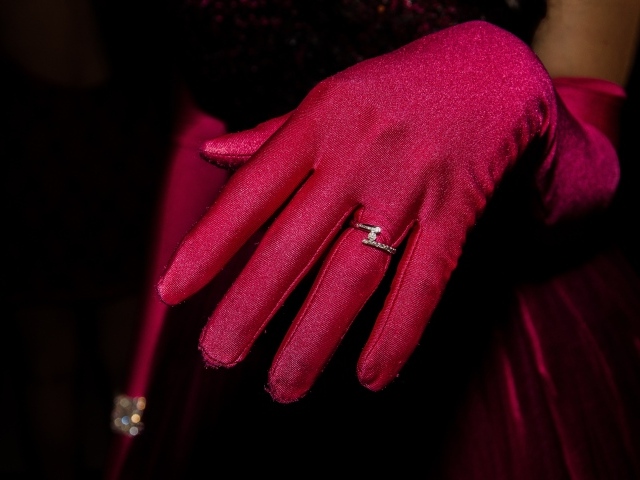 Женская рука с красной перчаткой и кольцом