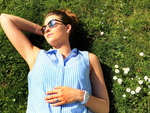 Девушка в солнечных очках лежит на траве
