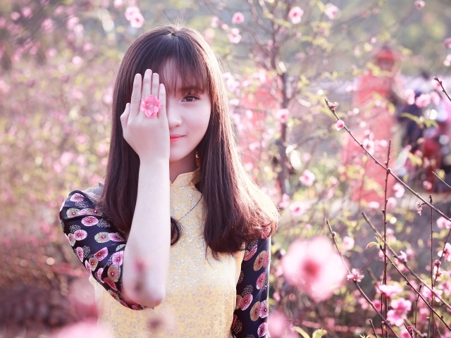 Девушка азиатка закрыла глаз рукой